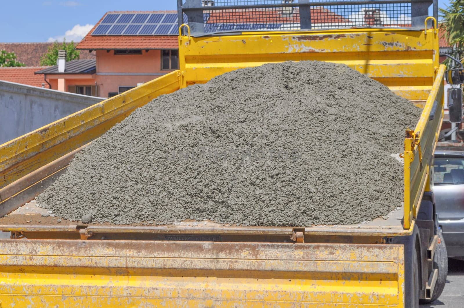 Yellow lorry transporting concrete to road works construction site