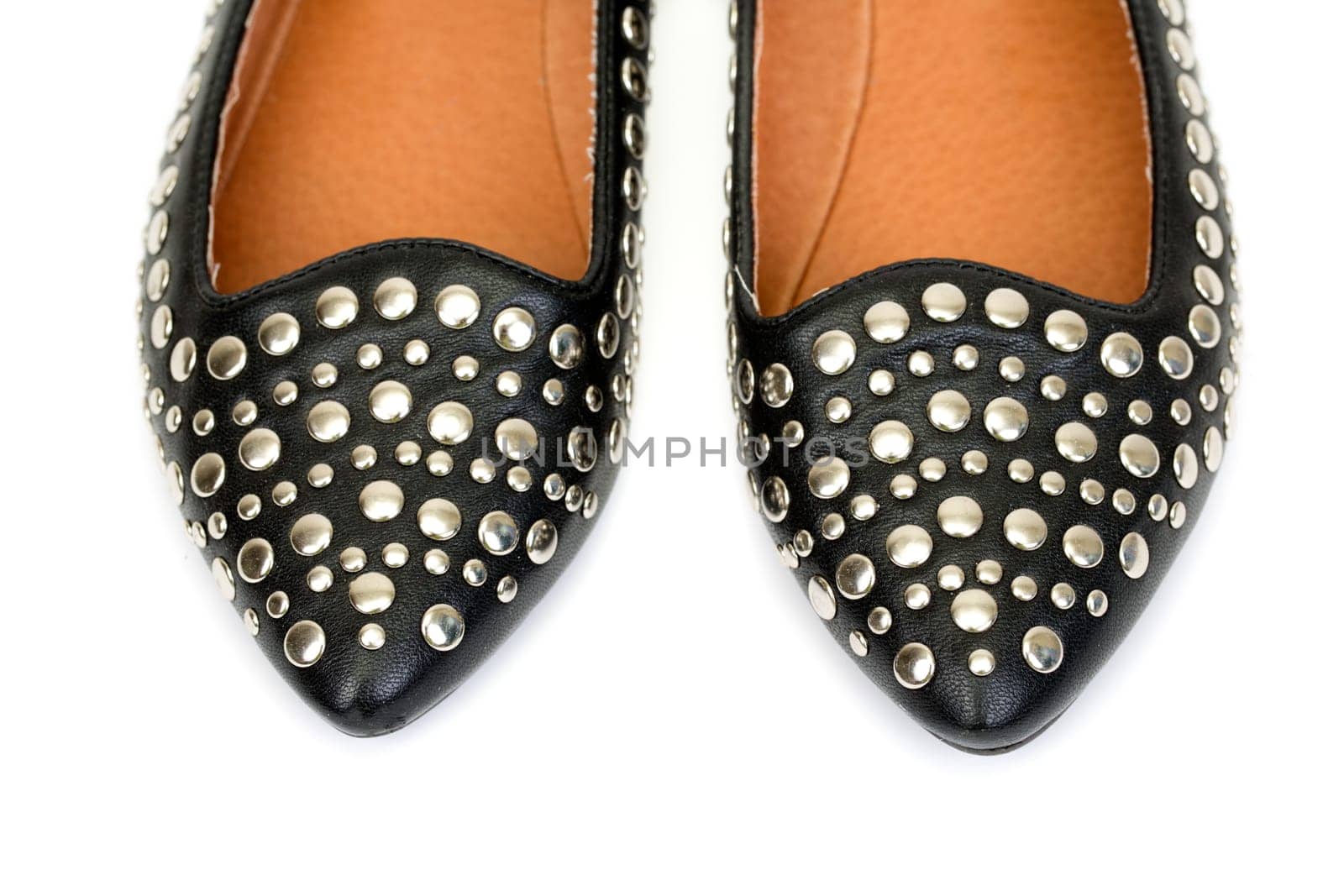 Black women's leather ballet flats with steel rivets close up on a white background