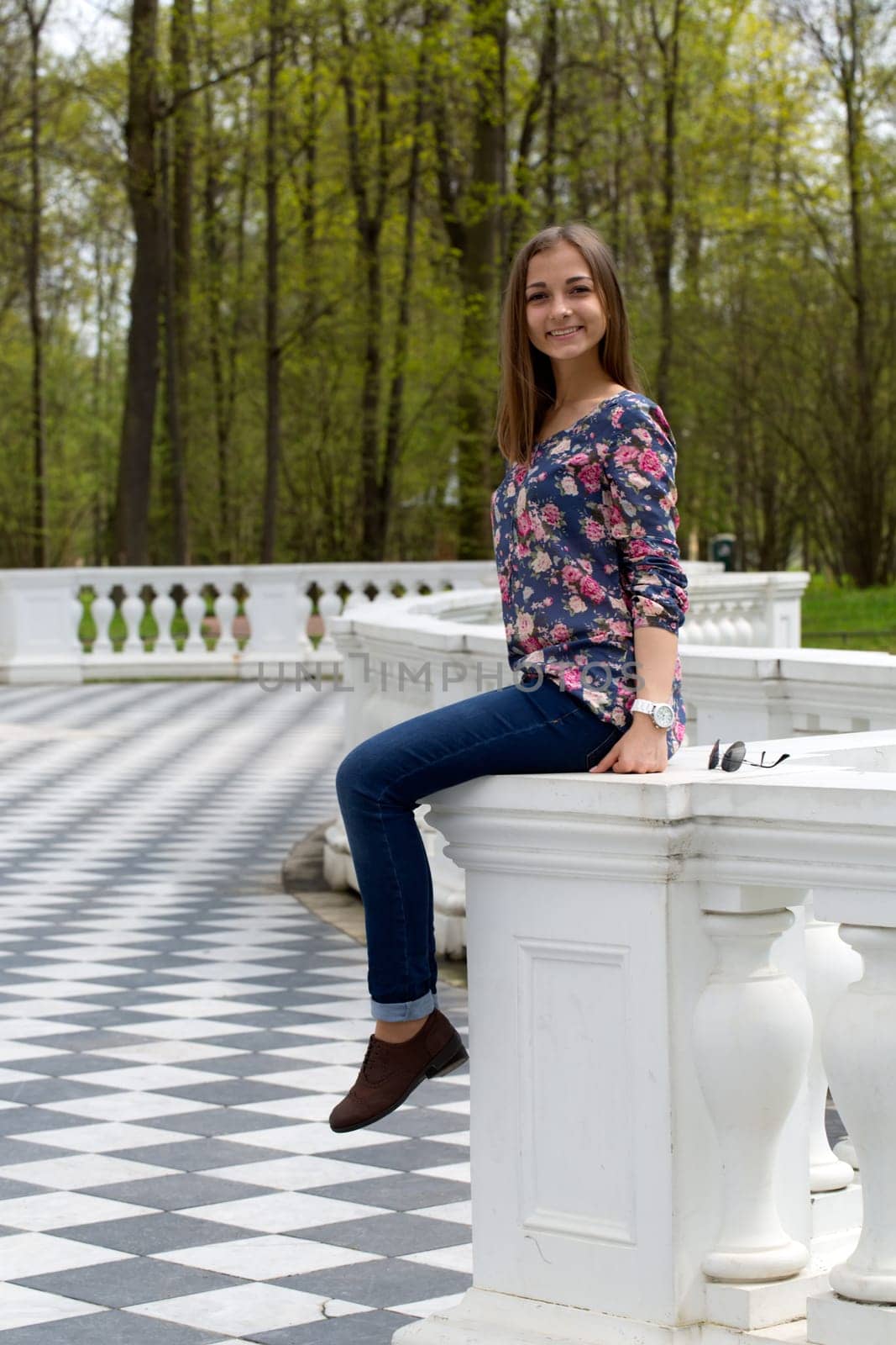 girl sitting on the railing in the park