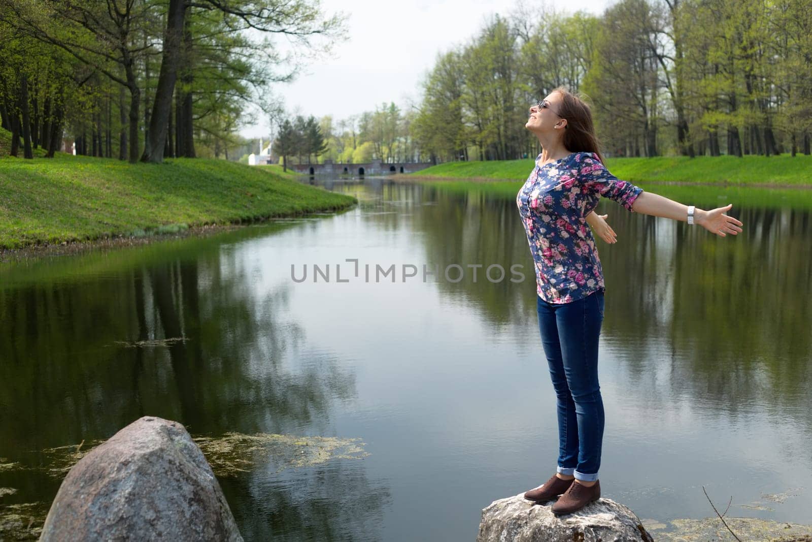 beautiful young woman opened her hands with delight at the park