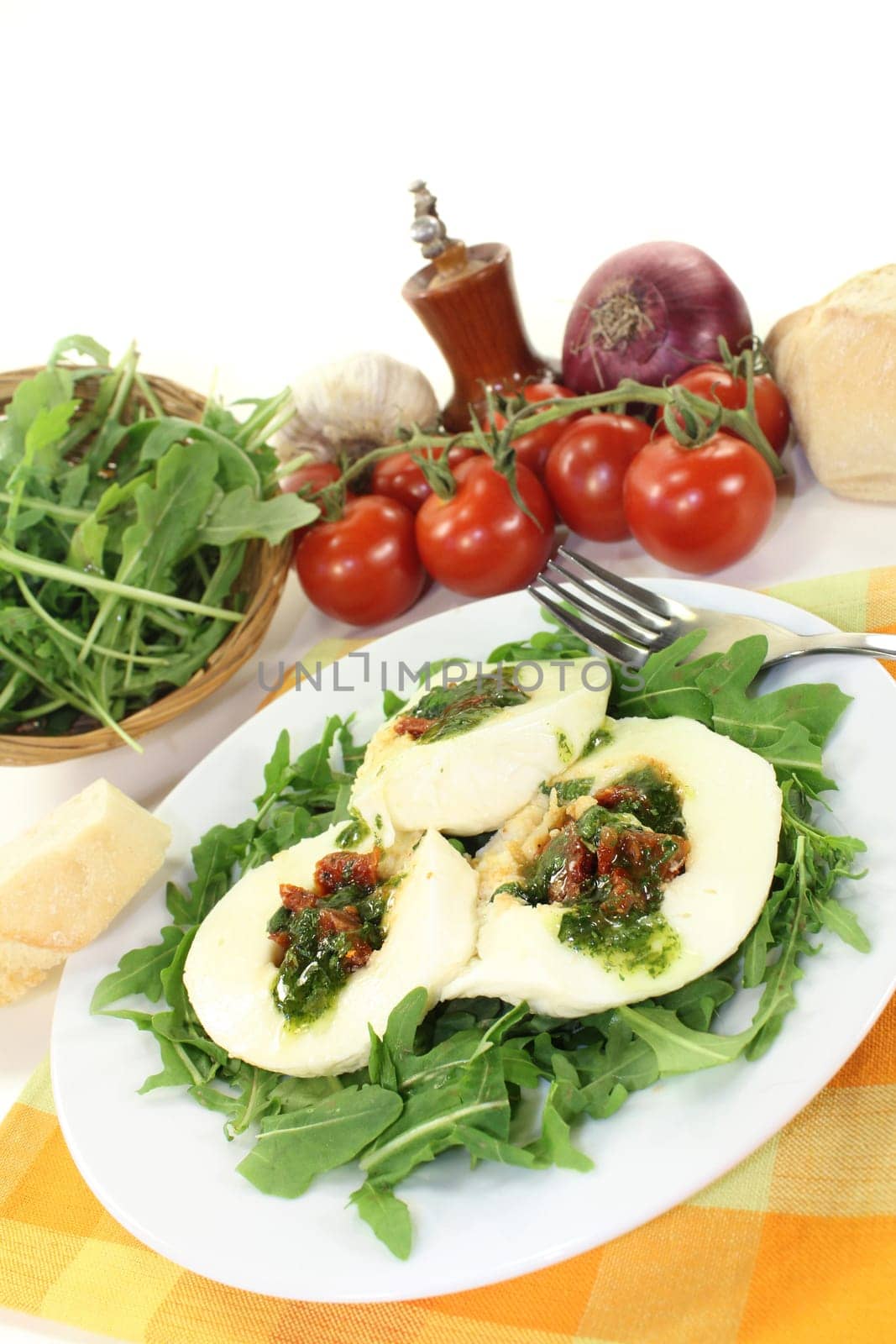 stuffed mozzarella on a bed of rocket against a white background