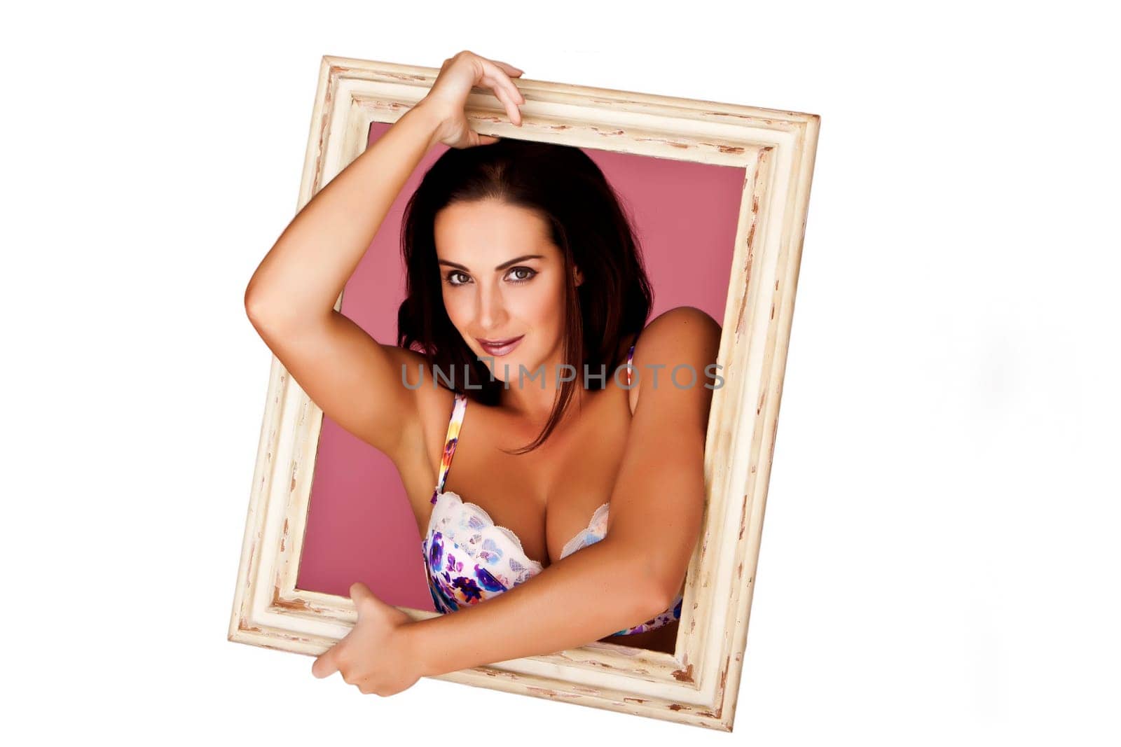 An abstract image of a woman holding a old frame where it looks like she wants to climb out of it.