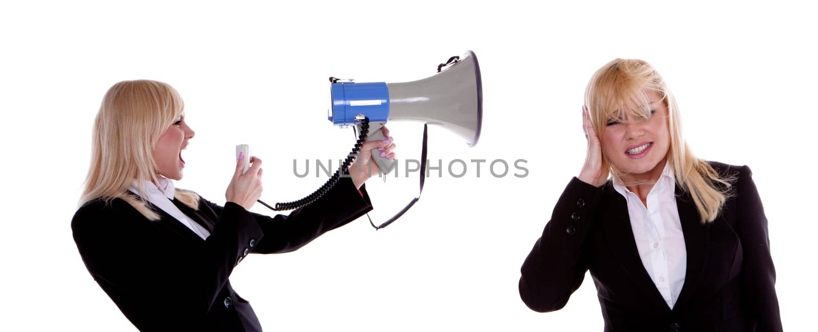 A beautiful blond businesswoman shouting trough a megaphone at herself.