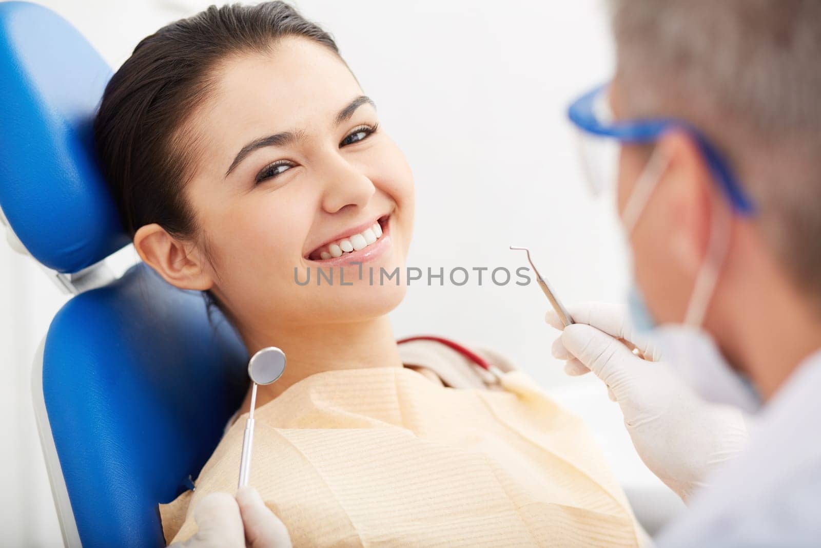 Image of smiling patient looking at camera at the dentist’s