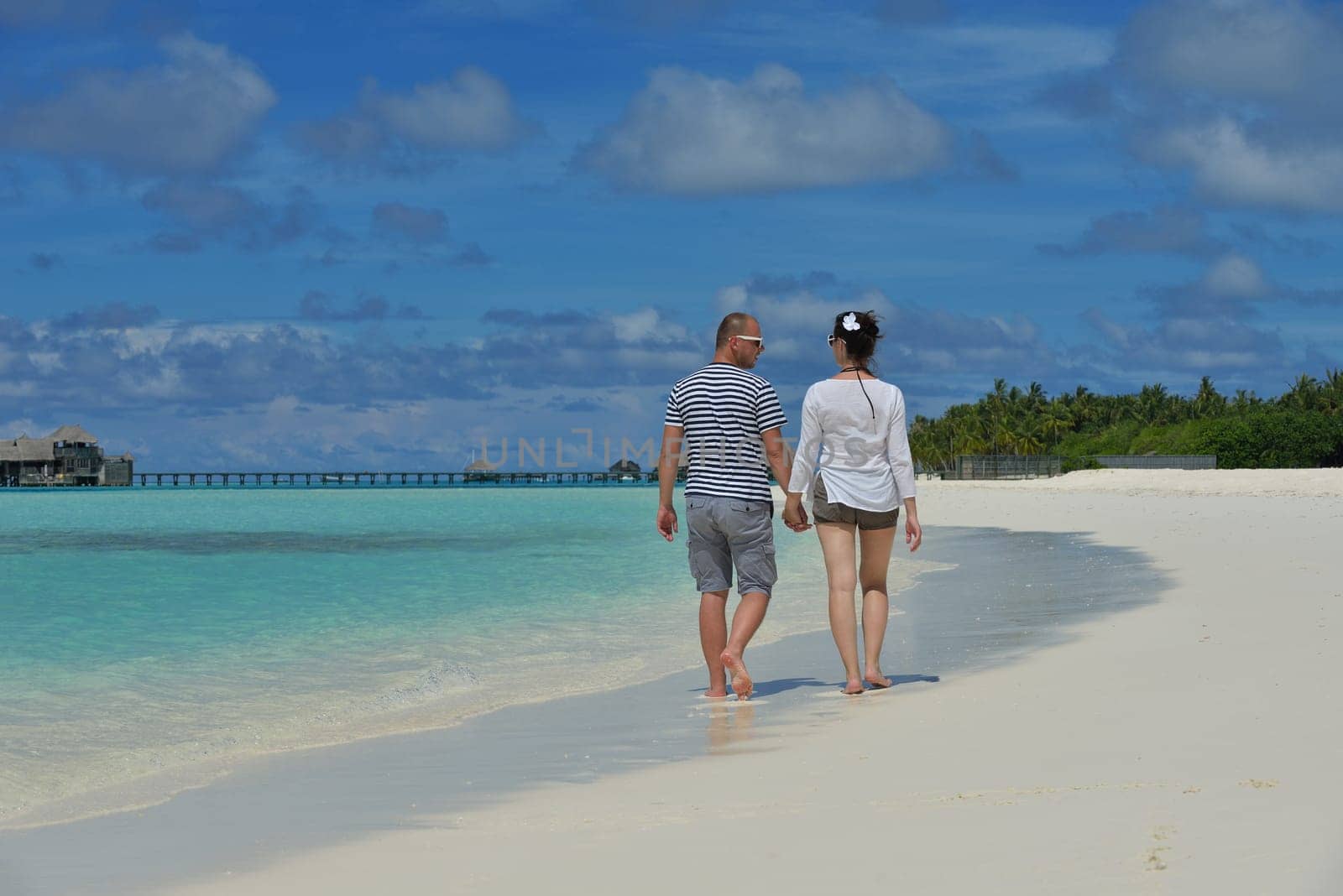 happy young couple have fun and relax at summer vacation on background maldives travel location and beautiful white sand beach