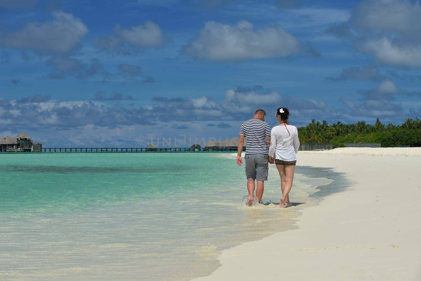 happy young couple have fun and relax at summer vacation on background maldives travel location and beautiful white sand beach