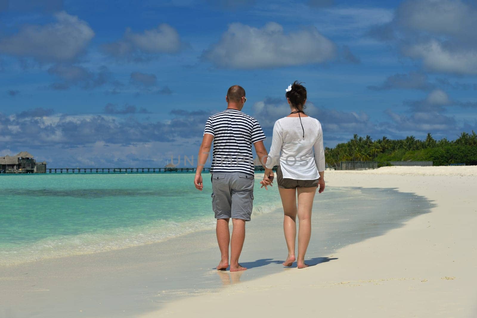 happy young couple have fun and relax at summer vacation on background maldives travel location and beautiful white sand beach
