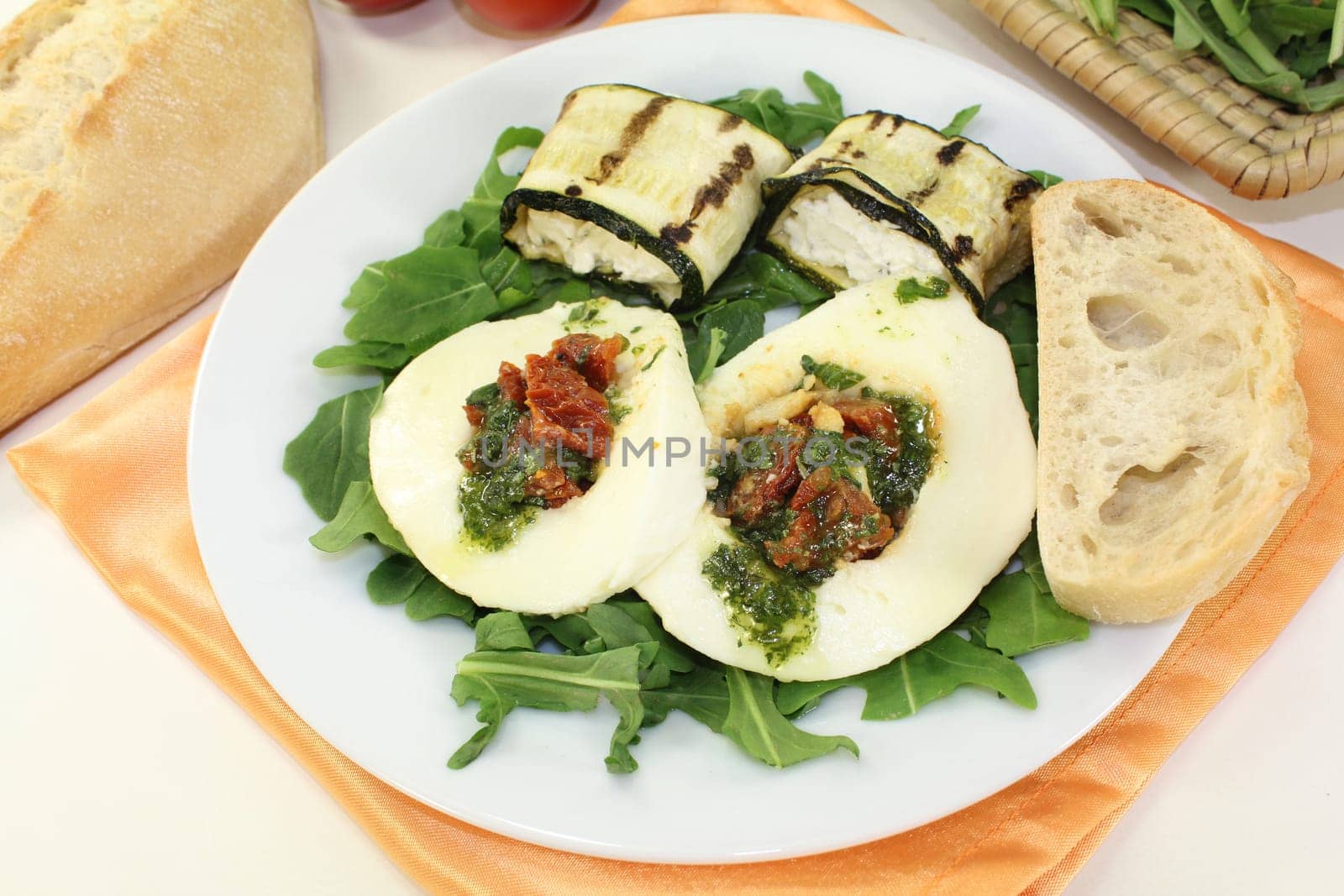 Zucchini rolls and stuffed mozzarella on a bed of rocket