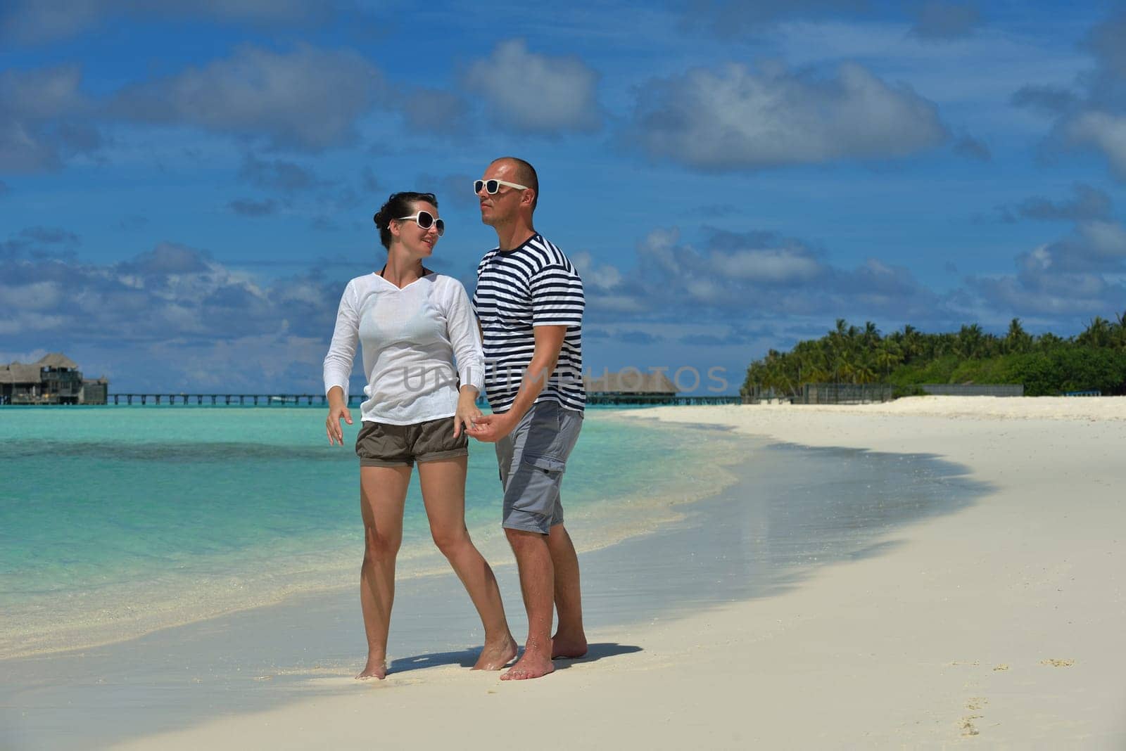 happy young couple have fun and relax at summer vacation on background maldives travel location and beautiful white sand beach