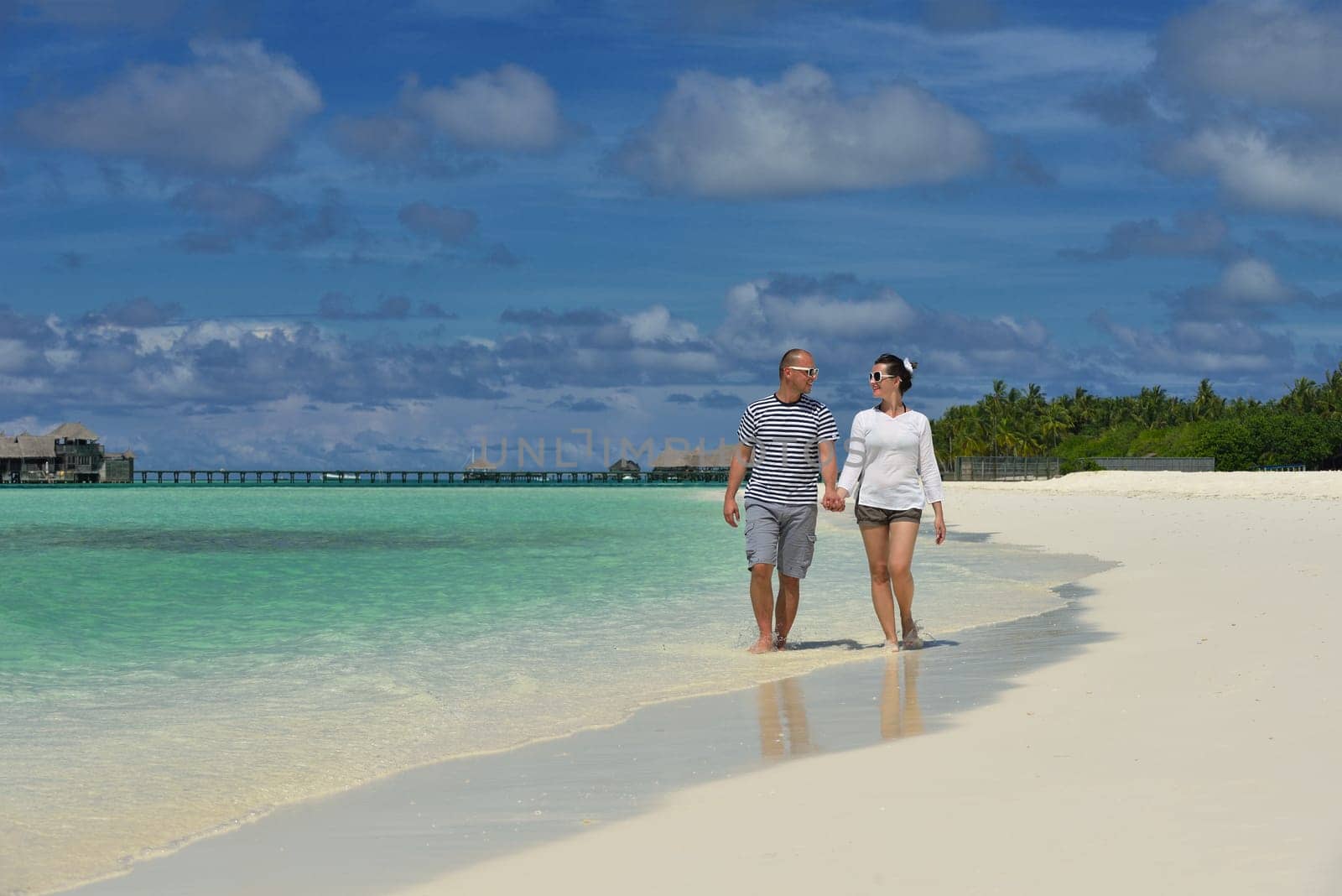 happy young couple have fun and relax at summer vacation on background maldives travel location and beautiful white sand beach