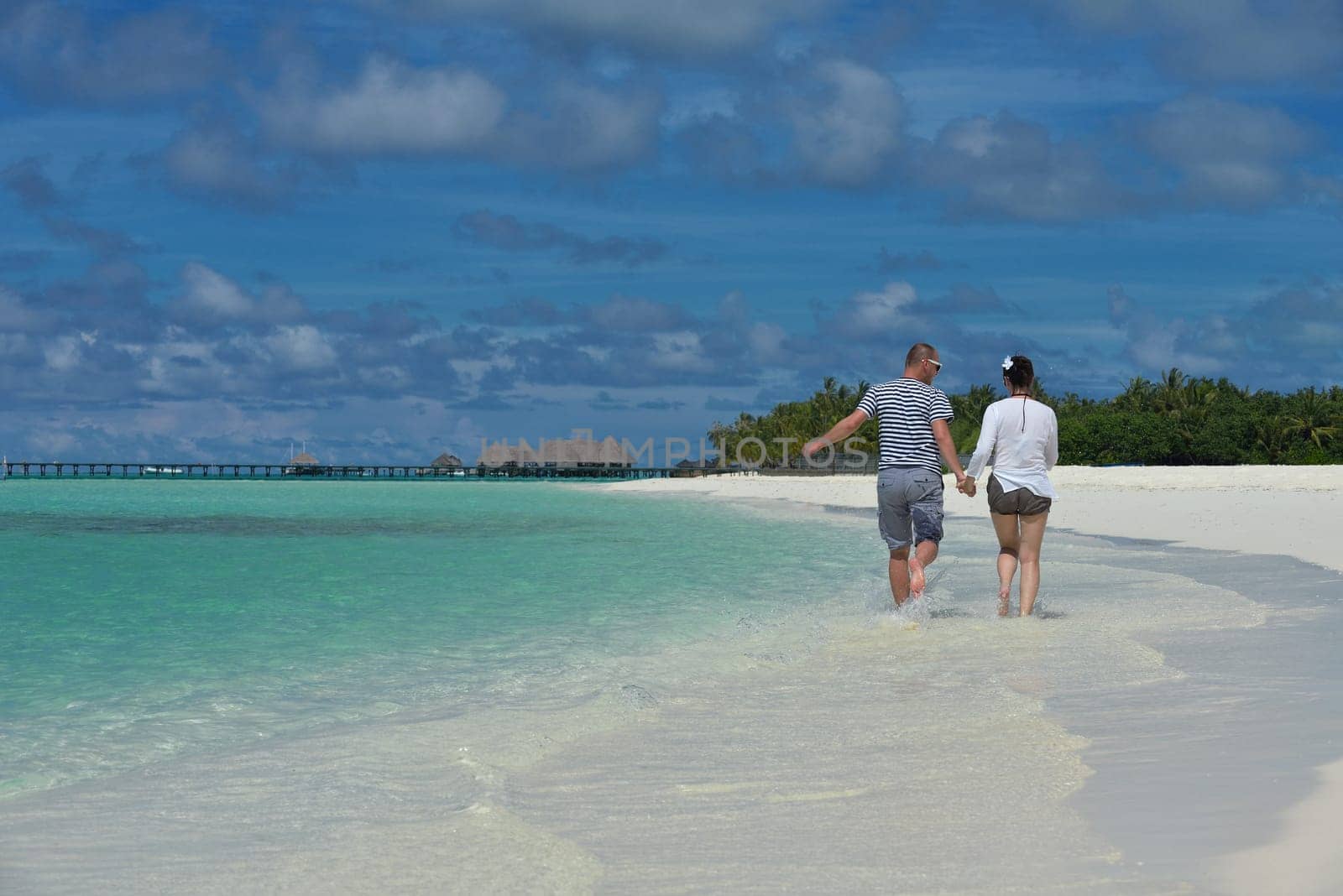 happy young couple have fun and relax at summer vacation on background maldives travel location and beautiful white sand beach