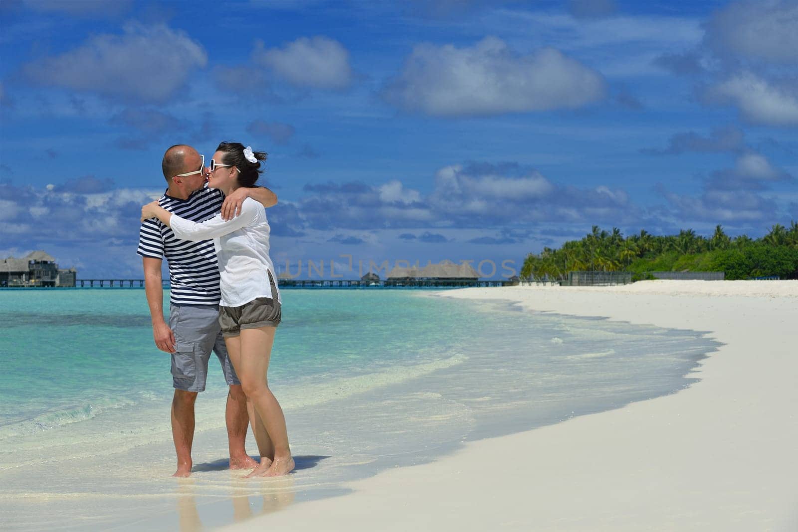 happy young couple have fun and relax at summer vacation on background maldives travel location and beautiful white sand beach
