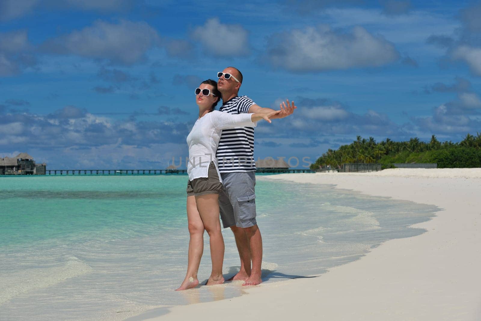 happy young couple have fun and relax at summer vacation on background maldives travel location and beautiful white sand beach