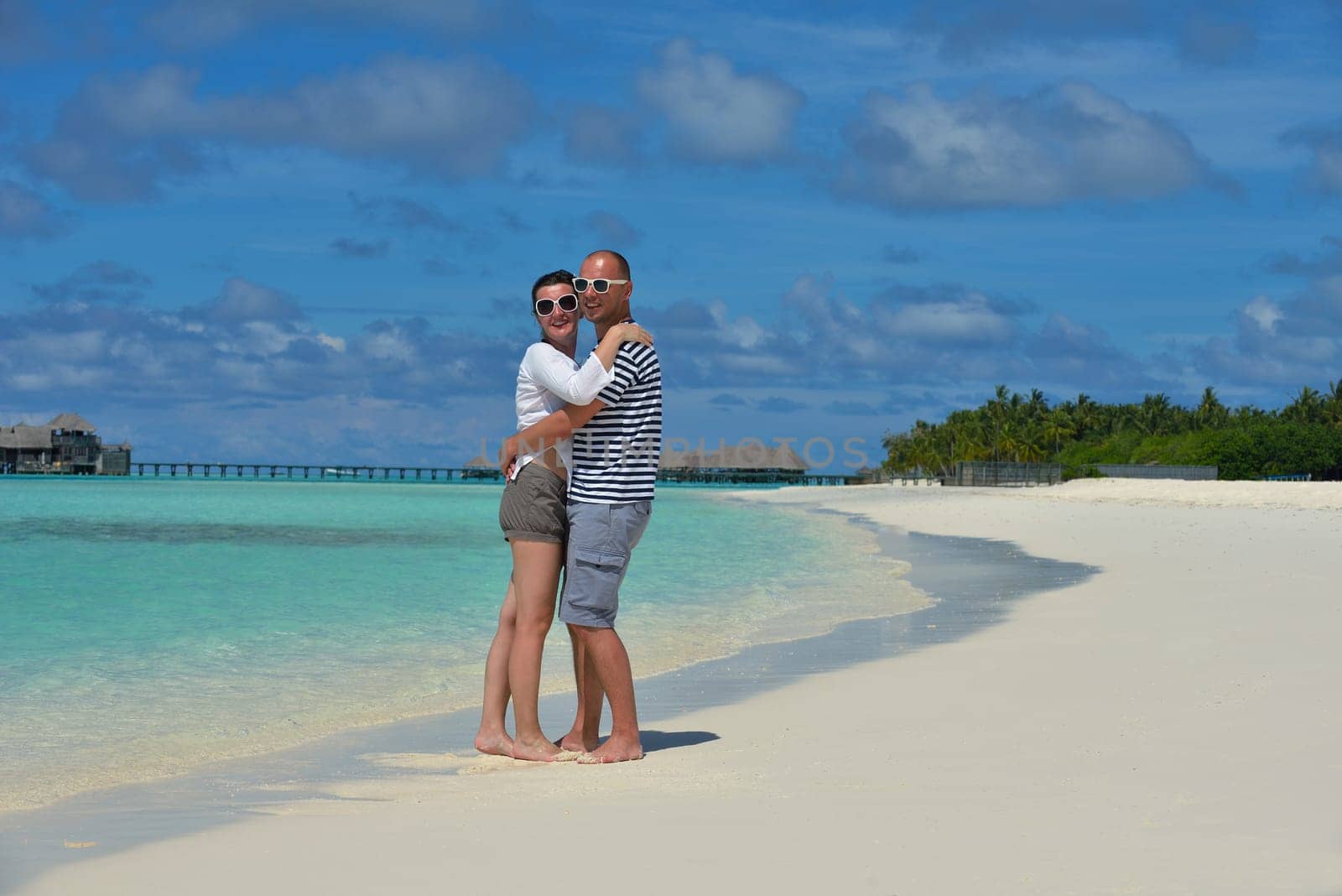 happy young couple have fun and relax at summer vacation on background maldives travel location and beautiful white sand beach