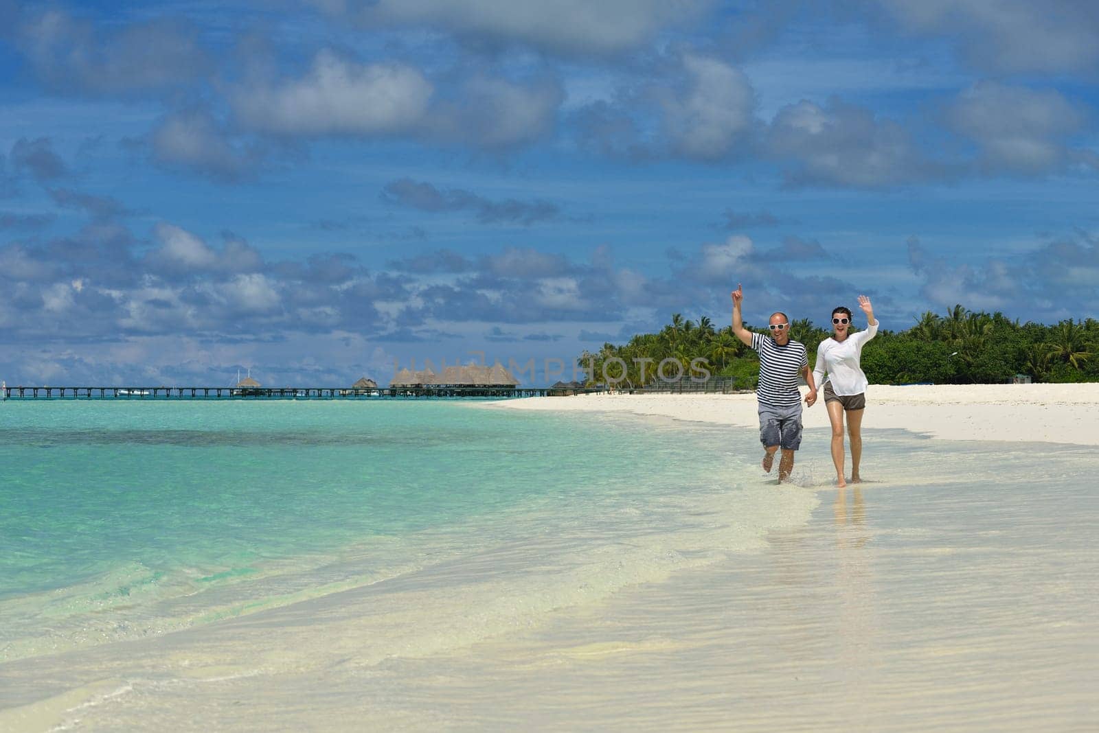 happy young couple have fun and relax at summer vacation on background maldives travel location and beautiful white sand beach