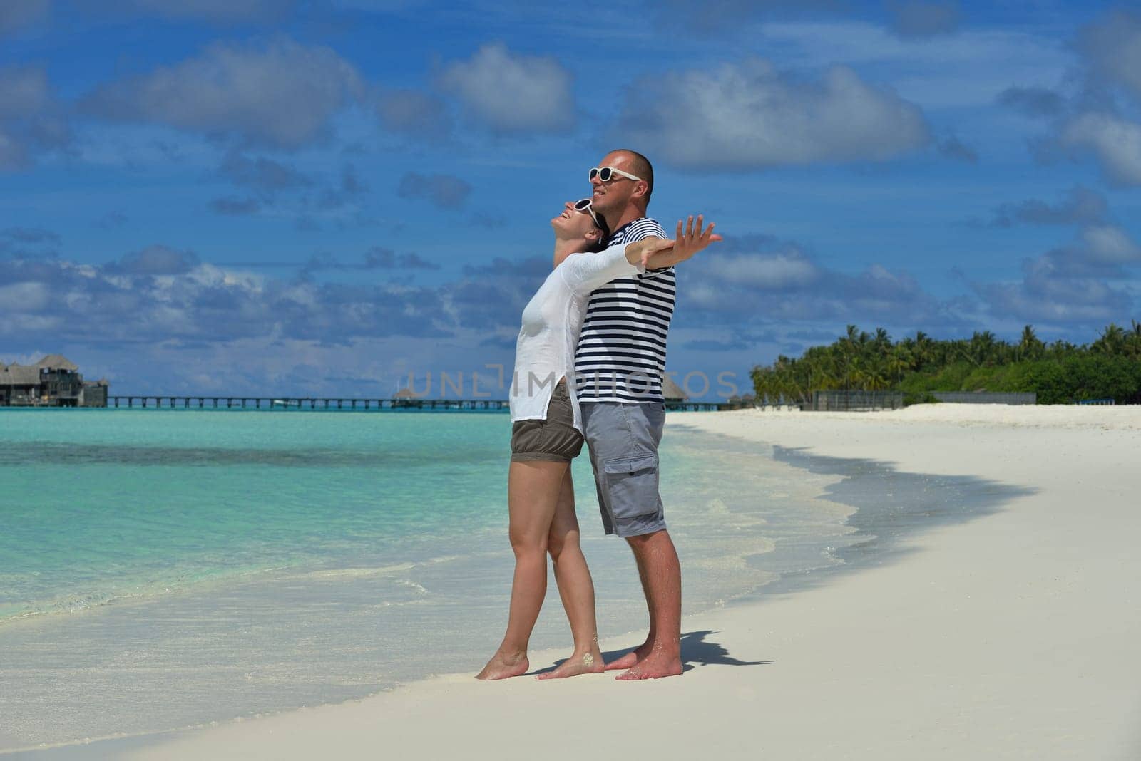 happy young couple have fun and relax at summer vacation on background maldives travel location and beautiful white sand beach