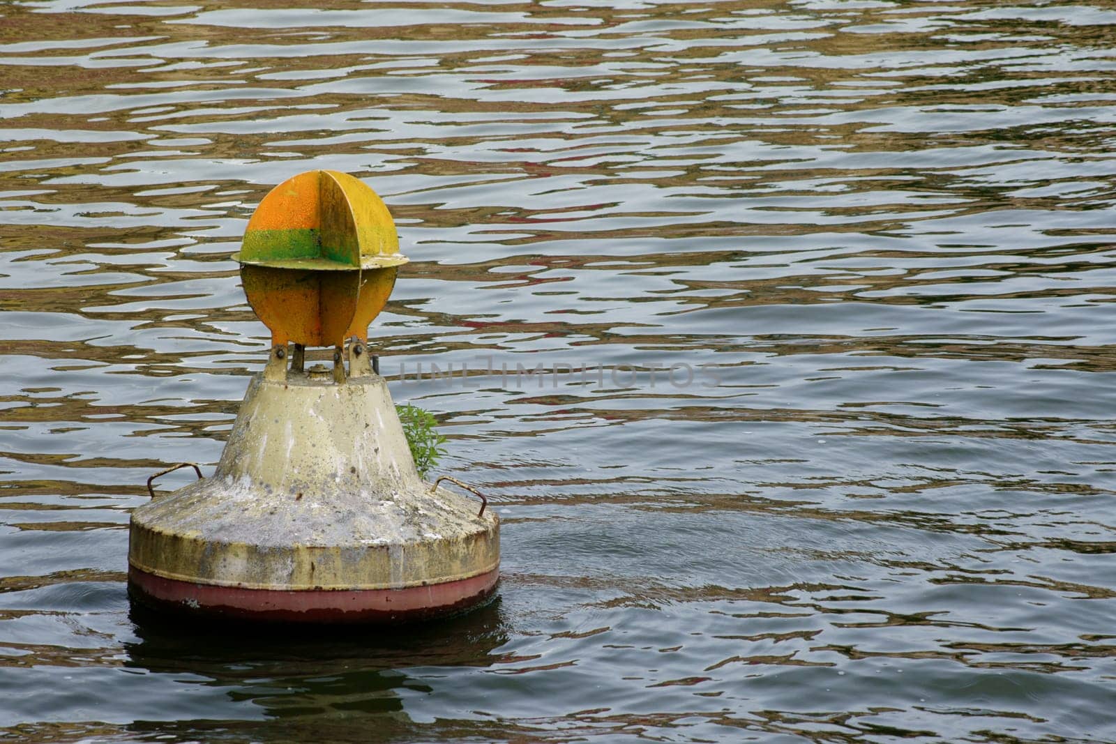 The photograph of a buoy on a strikingly undulating water surface.