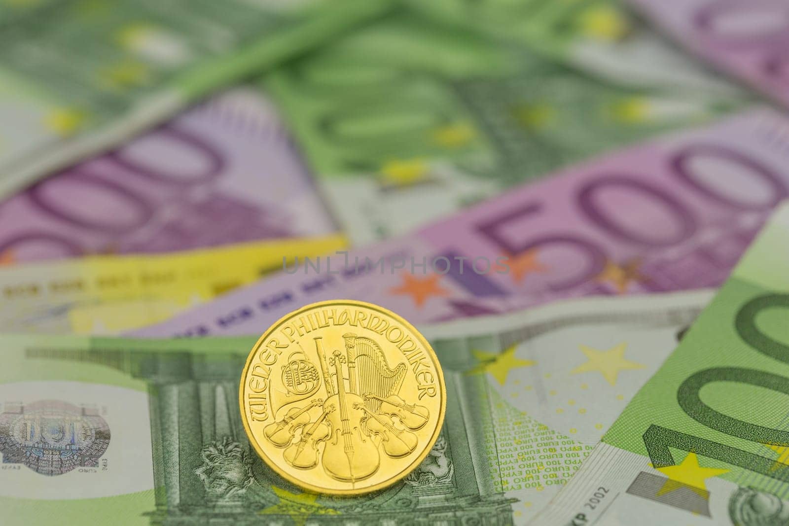 single gold coin on euro banknotes