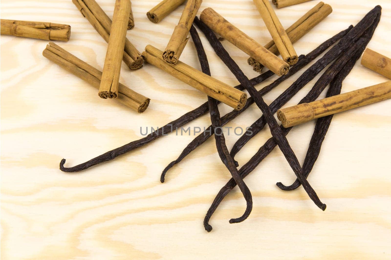 Vanilla pods and cinnamon on a wooden board
