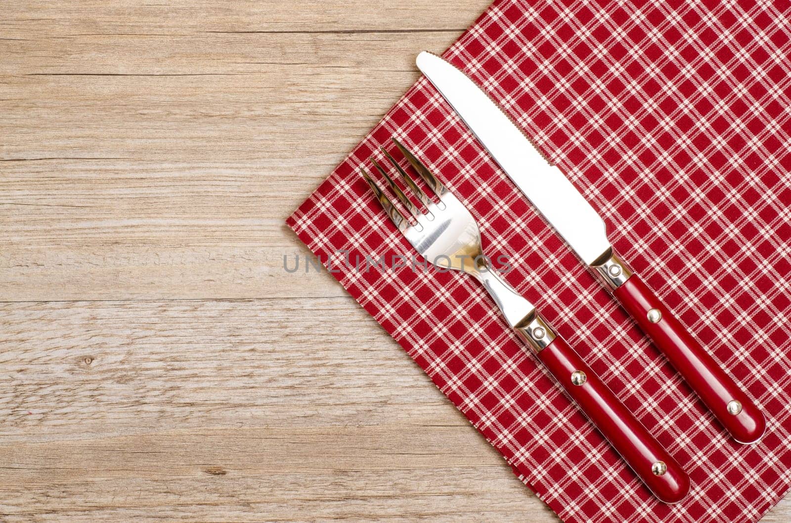 Knife and fork in red with checkered napkin