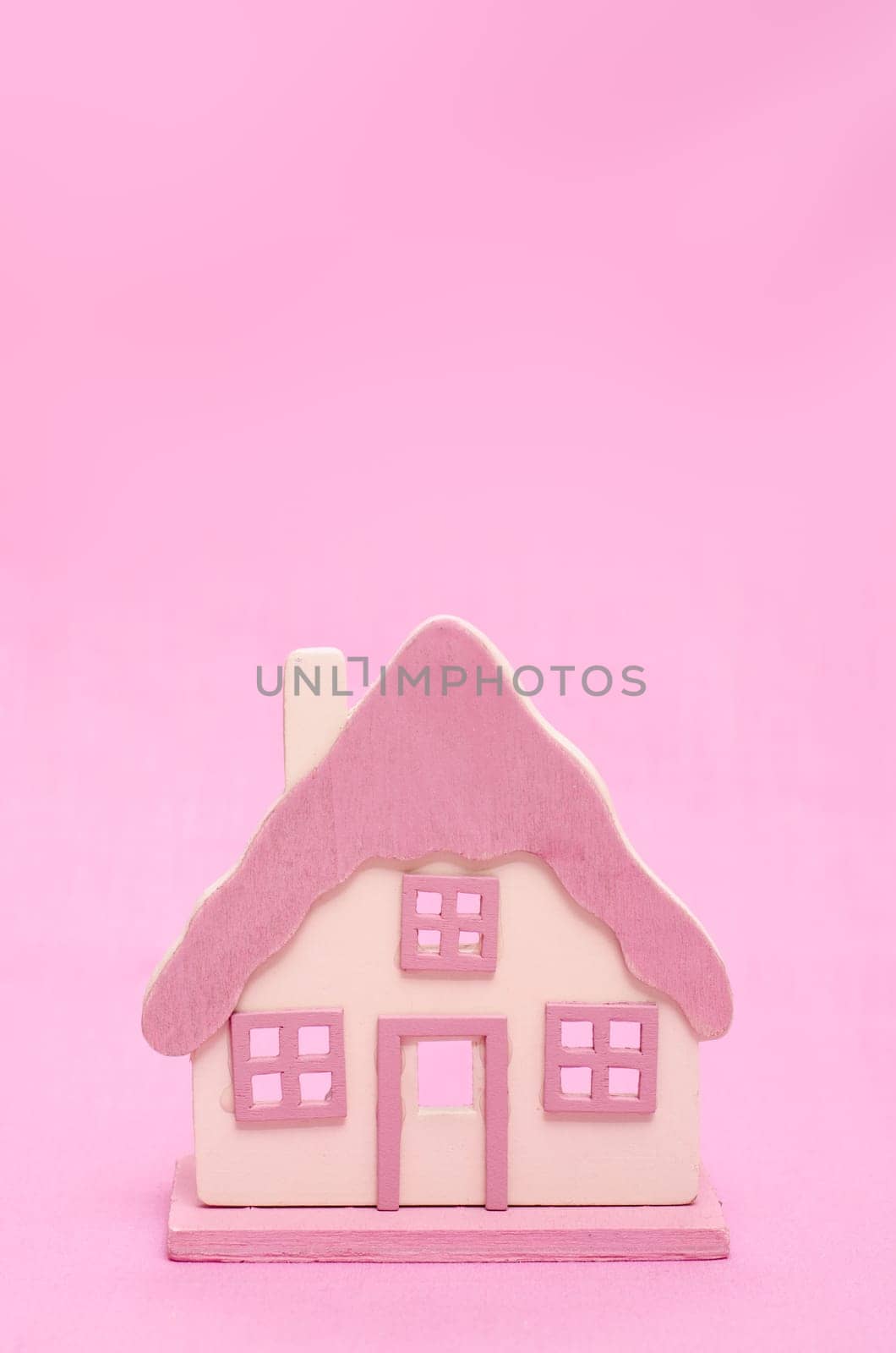 Pink house in front of pink background with text space for advertising