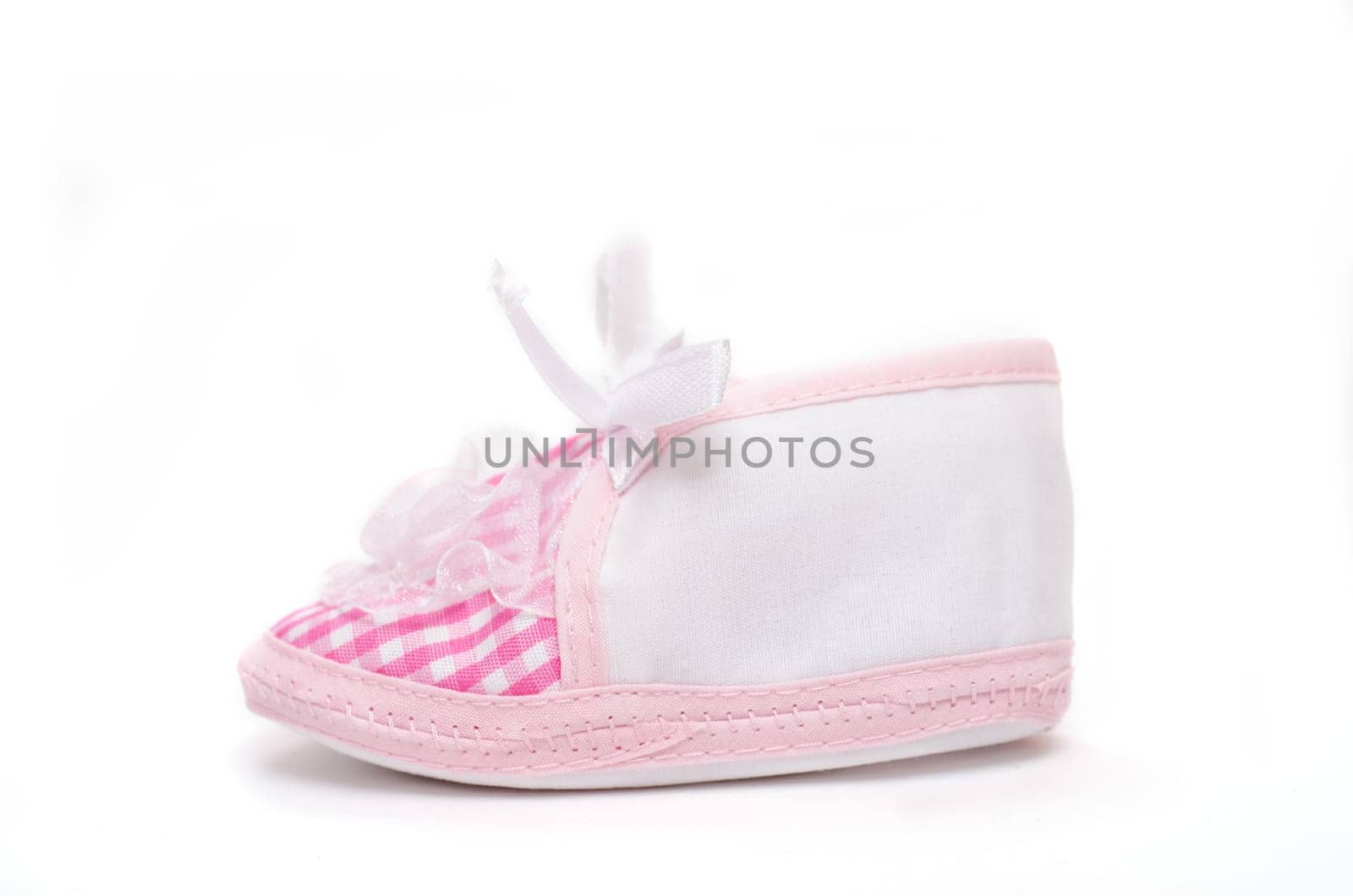 Pink baby shoe on white background