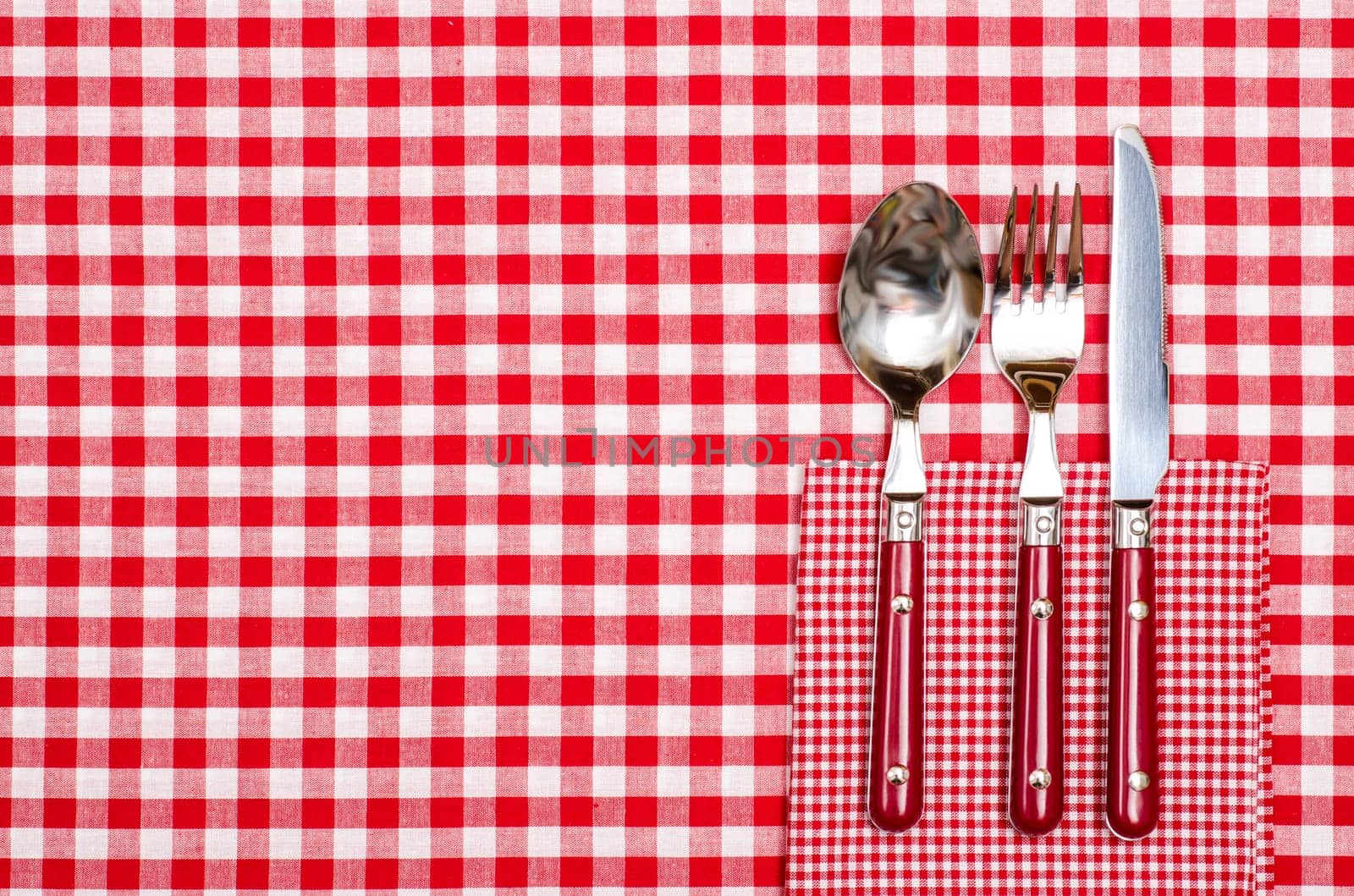 Table in restaurant with spoon,fork and knife in red