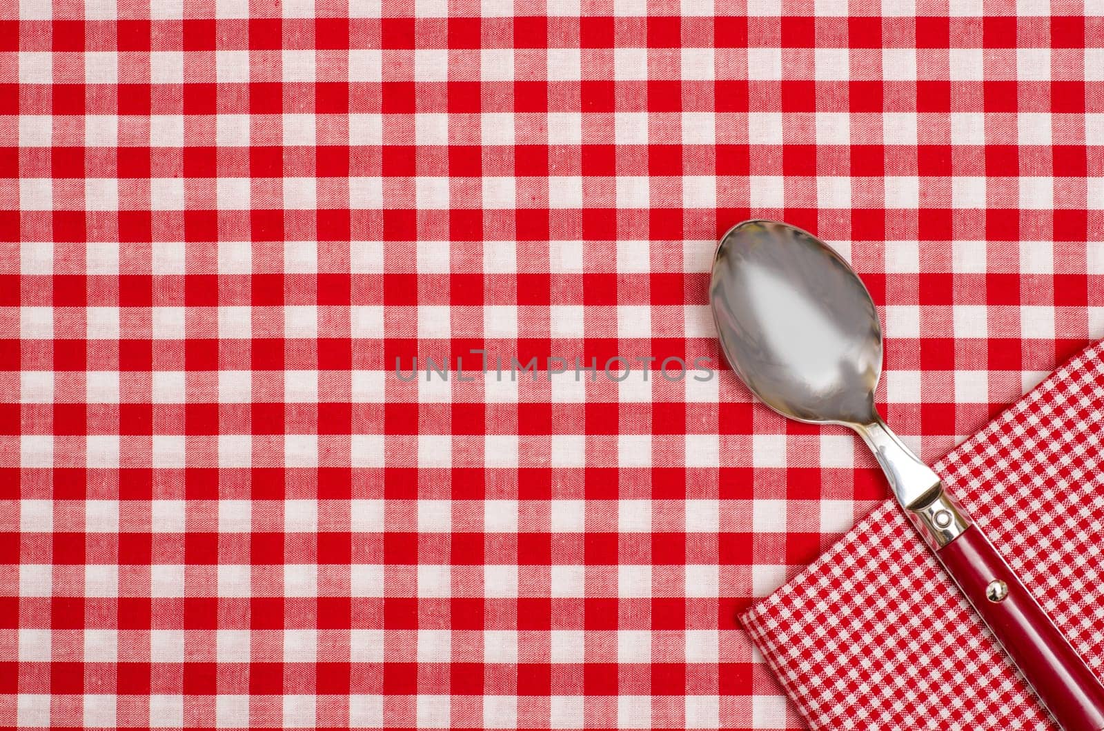 Tablecloth with red and white checks and napkin with spoon