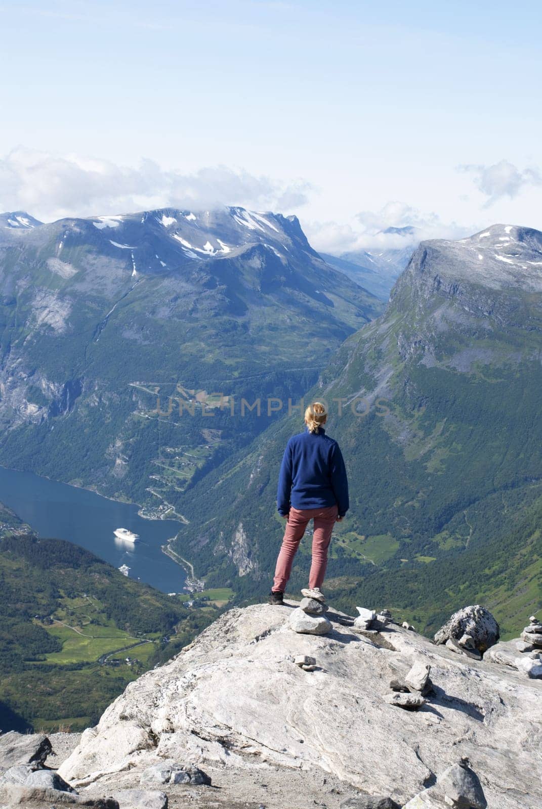 A Woman Standing on the Top of a Mountain Enjoying the View