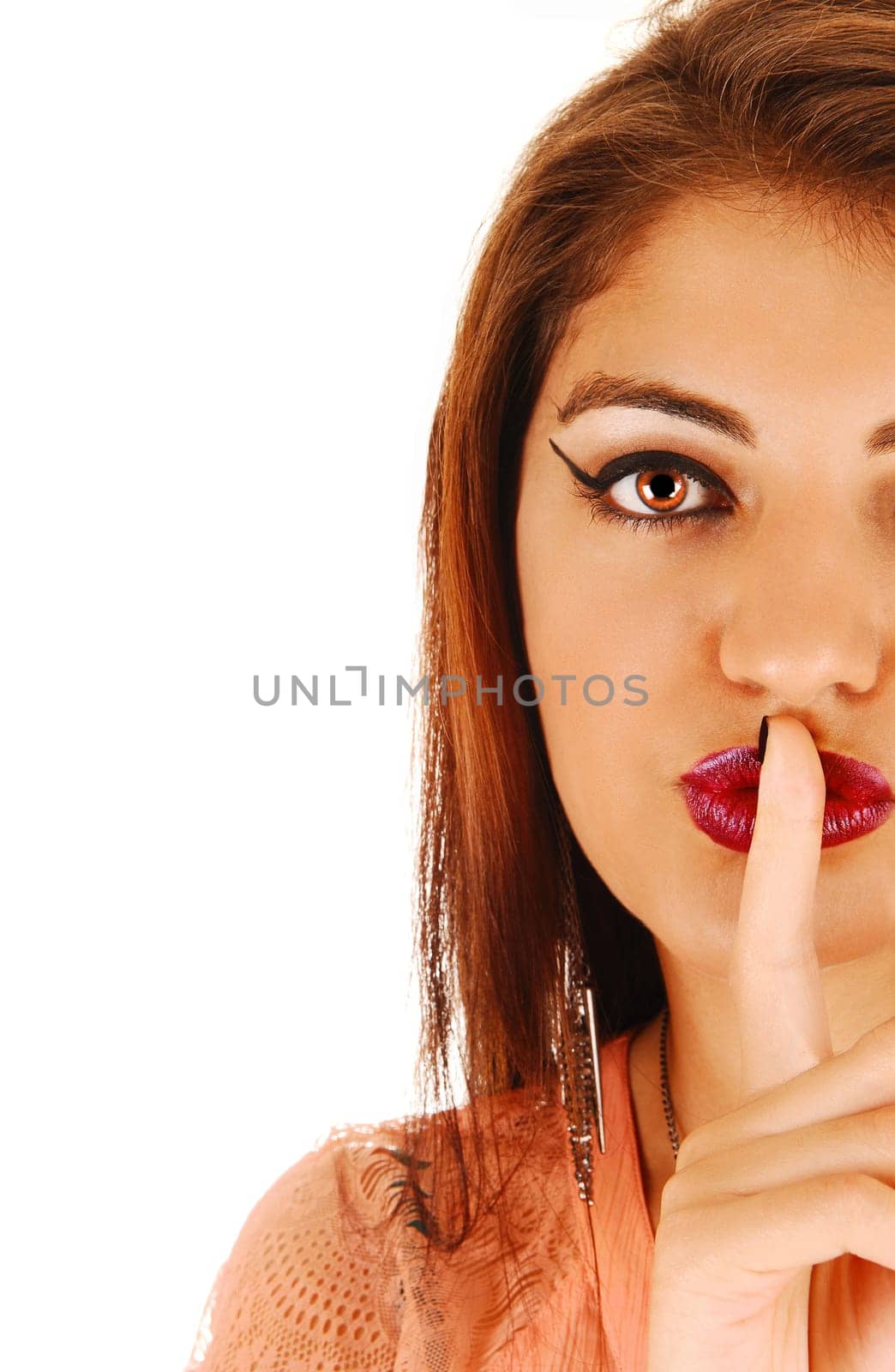 The half face of a gorgeous young woman with one finger over her.mouth, for white background..