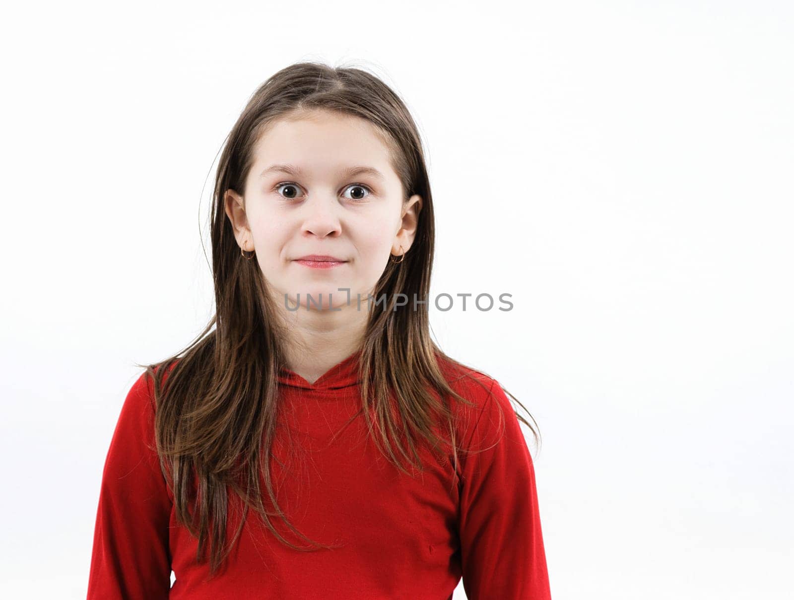 Child girl in red clothes stares forward