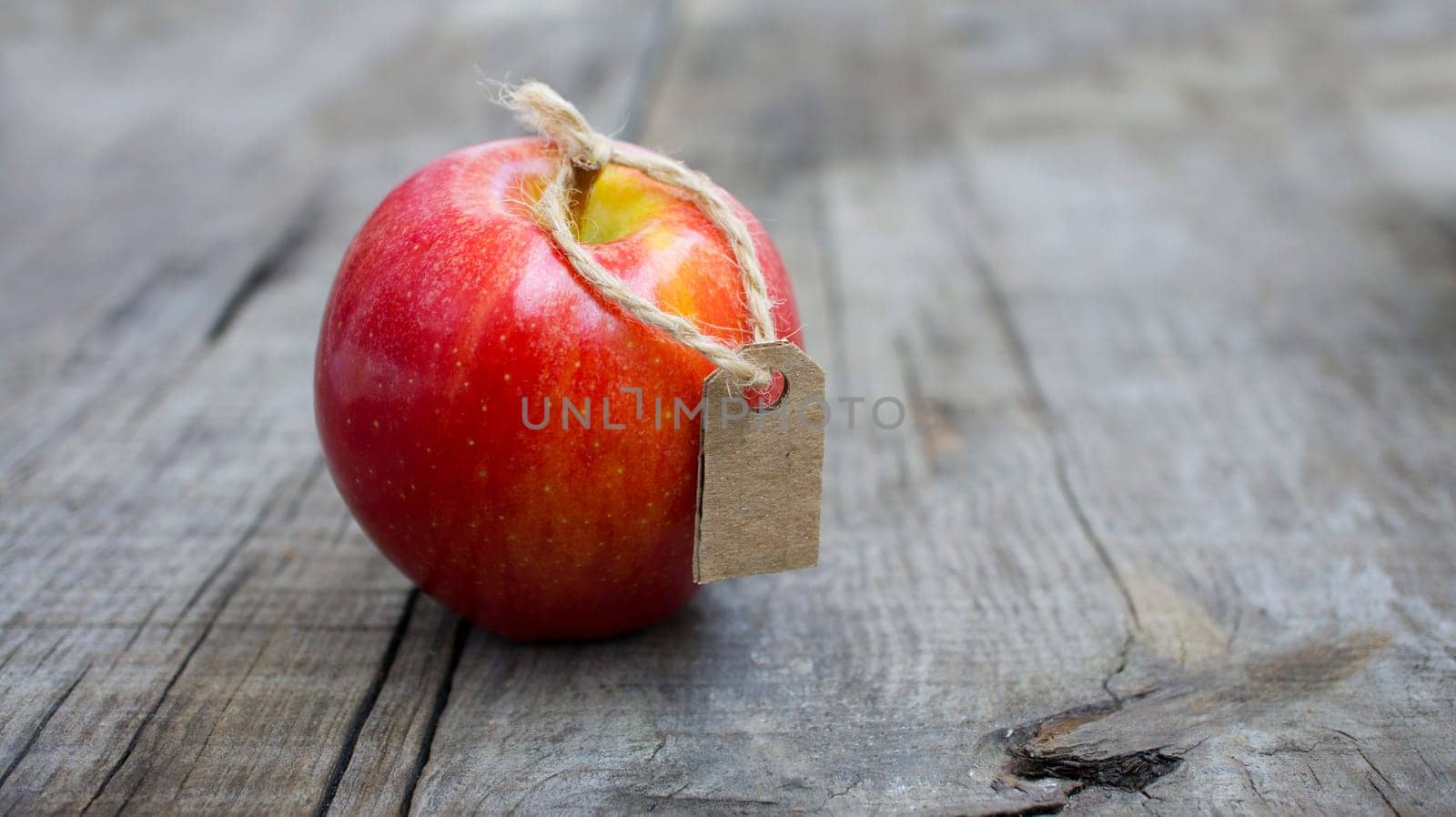 A Red Apple with a Price Label on wood background