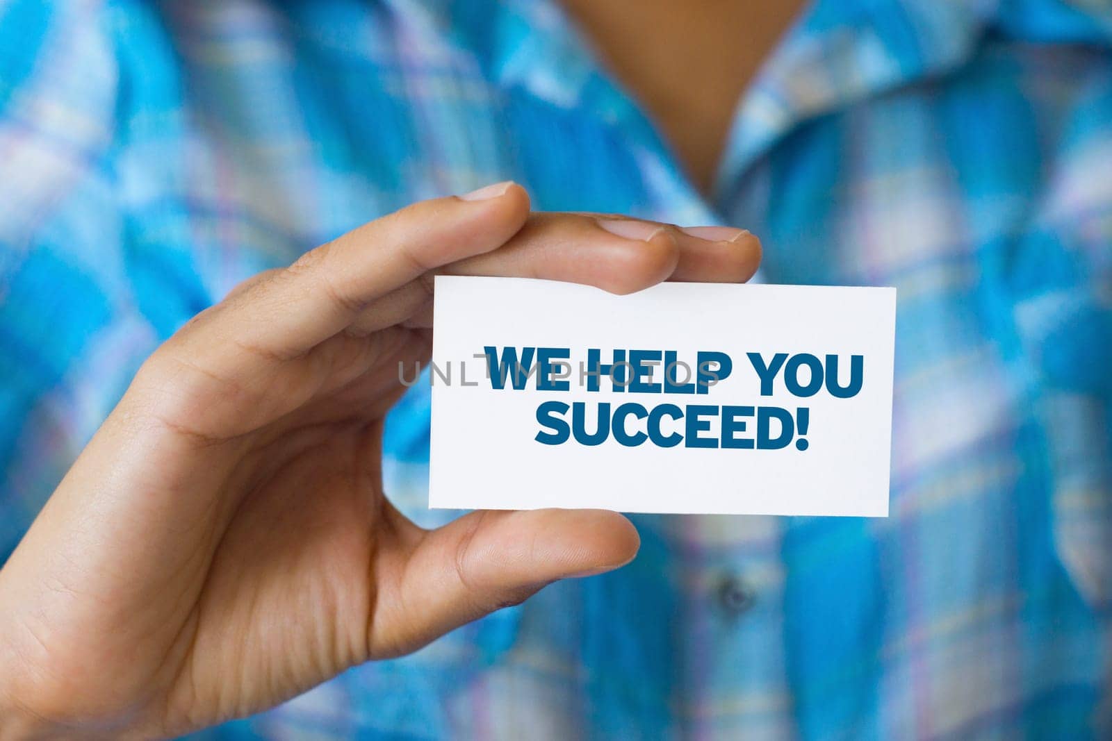 A person holding a white card with the words We help you Succeed