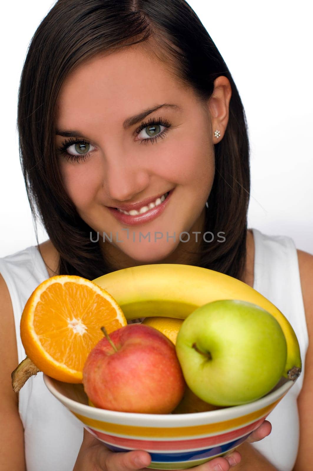 young brunette girl holding bowl with fruit close up