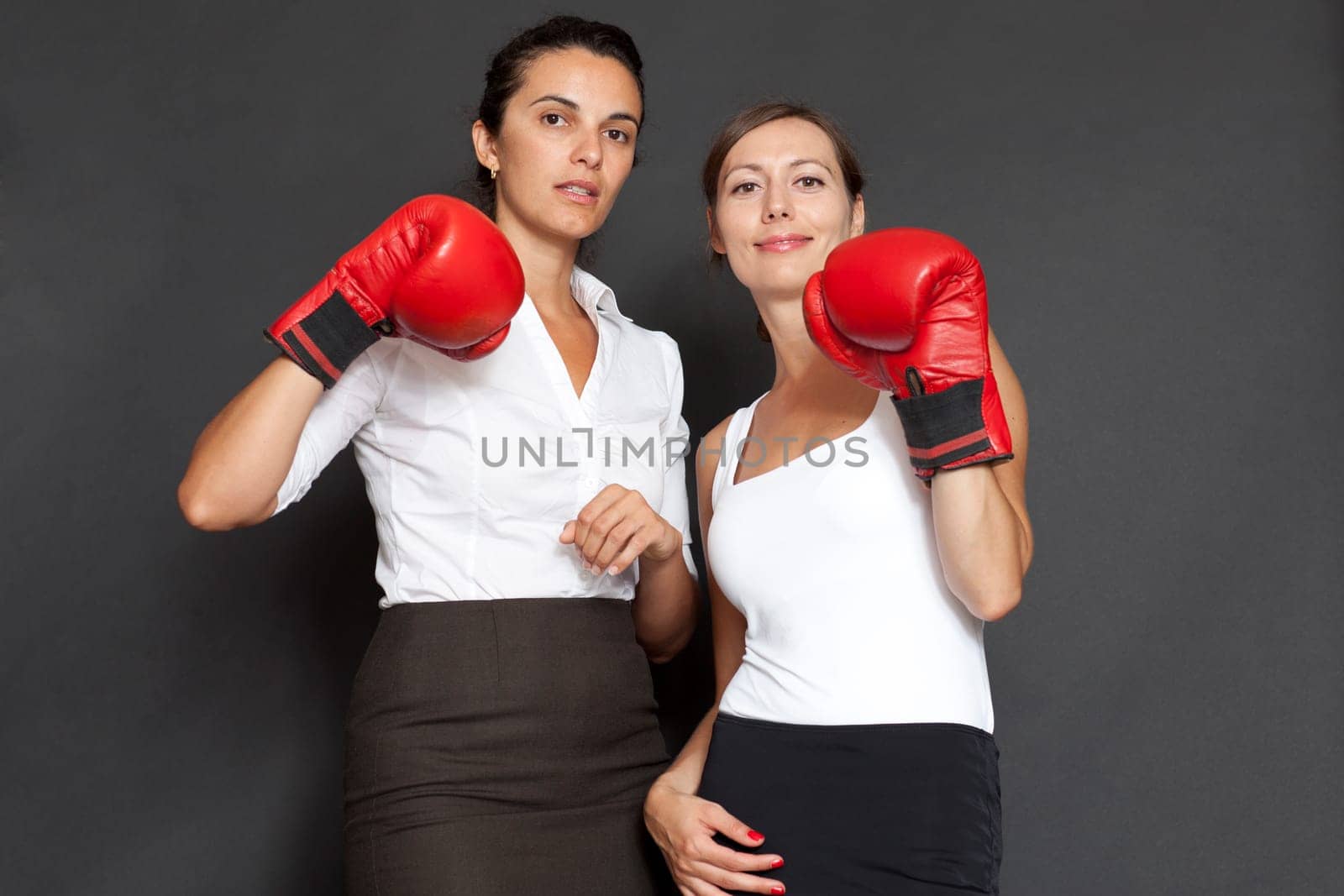 Two businesswomen with red boxing gloves