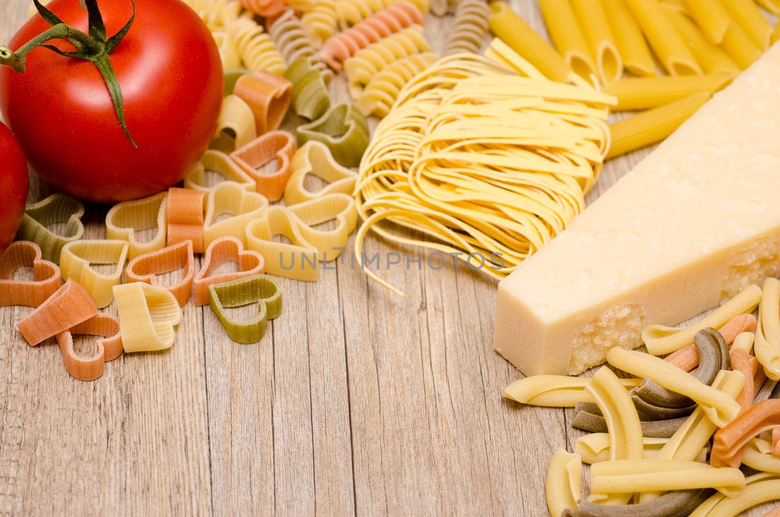 Various pasta,pecorino and tomato on a wooden board