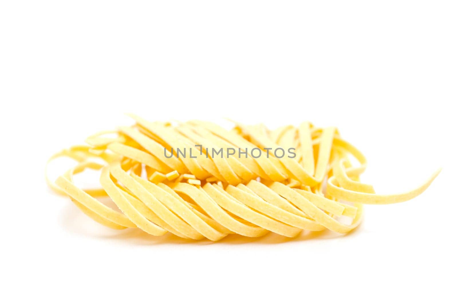 Yellow Taglerini pasta on white background