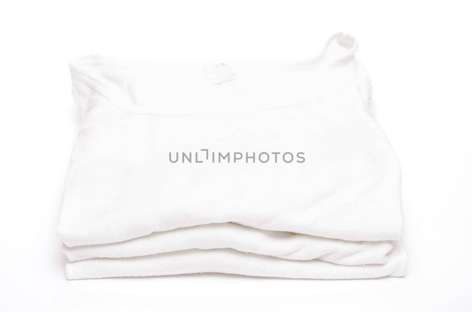 Three white undershirts on a pile