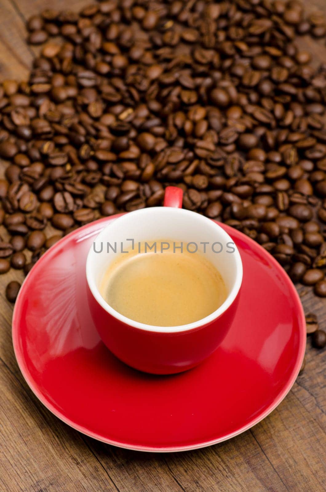 Red espresso cup with espresso coffee and coffee beans