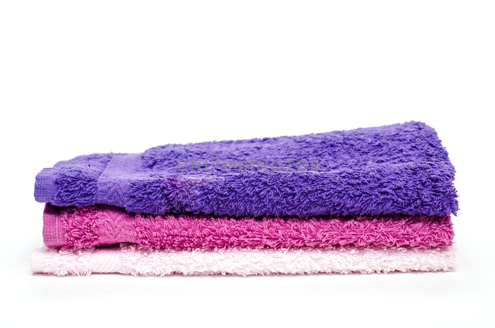 Three colourful terry cloth washcloths on a white background