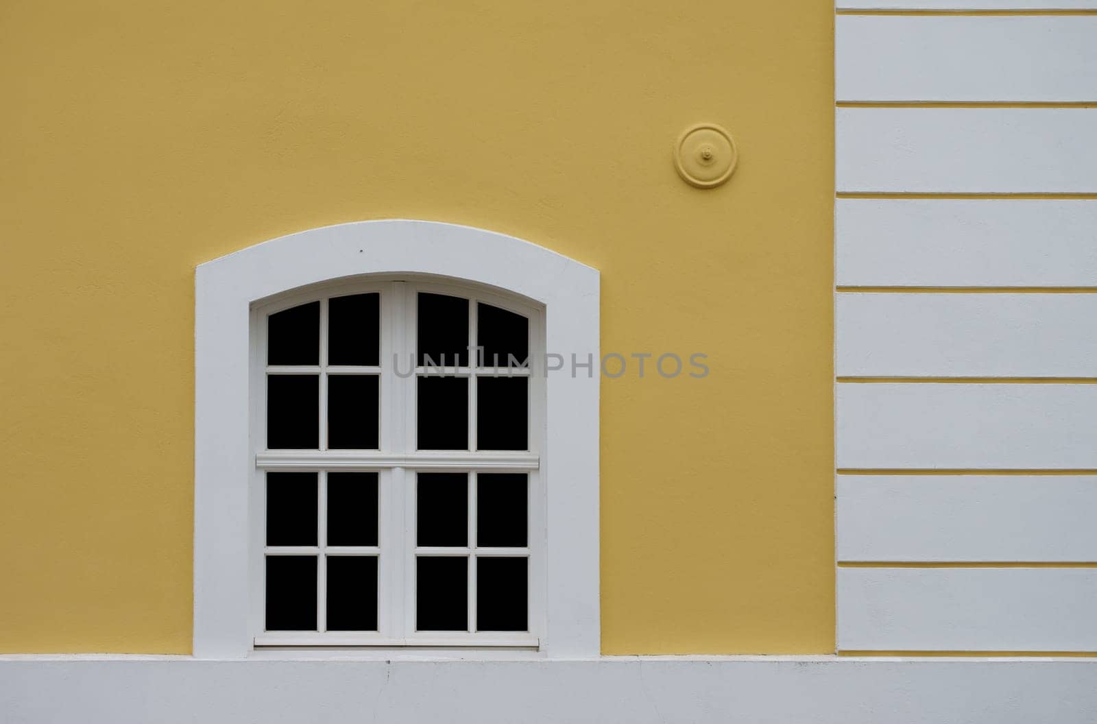 The photograph of a house façade with a window.