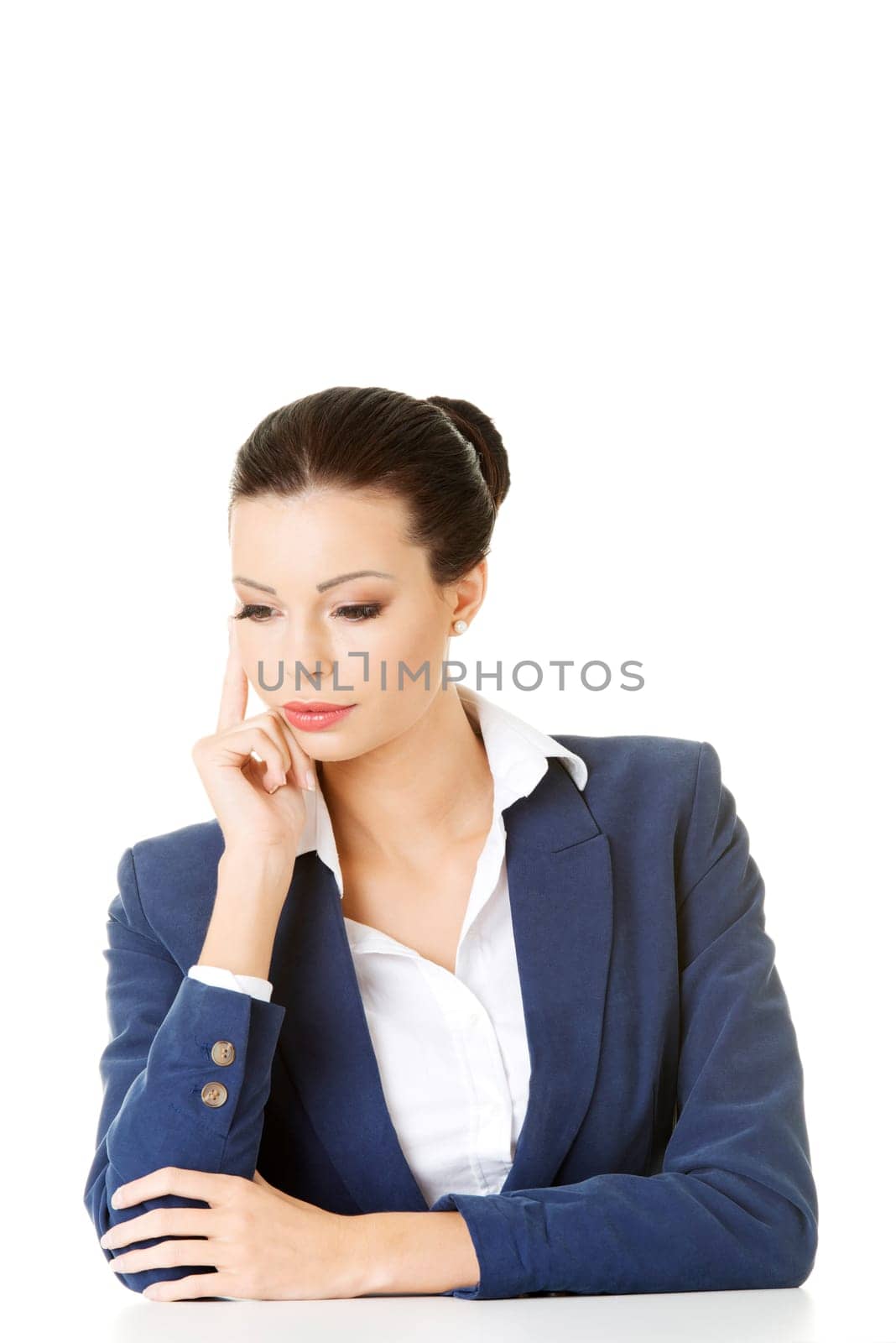 Pretty businesswoman sitting at the desk and thinking, isolated on white