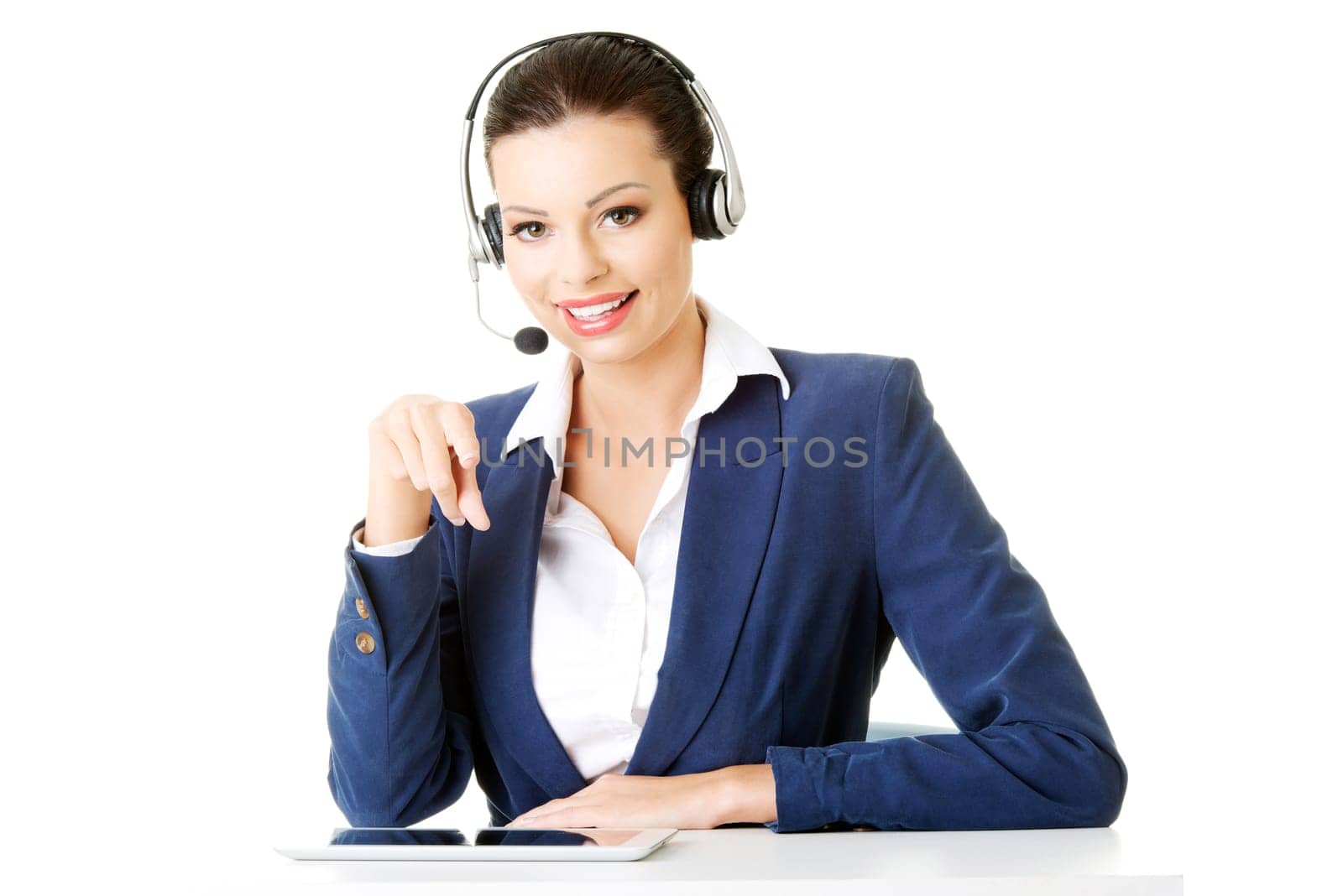 Beautiful young call-center assistant at the desk, isolated on white