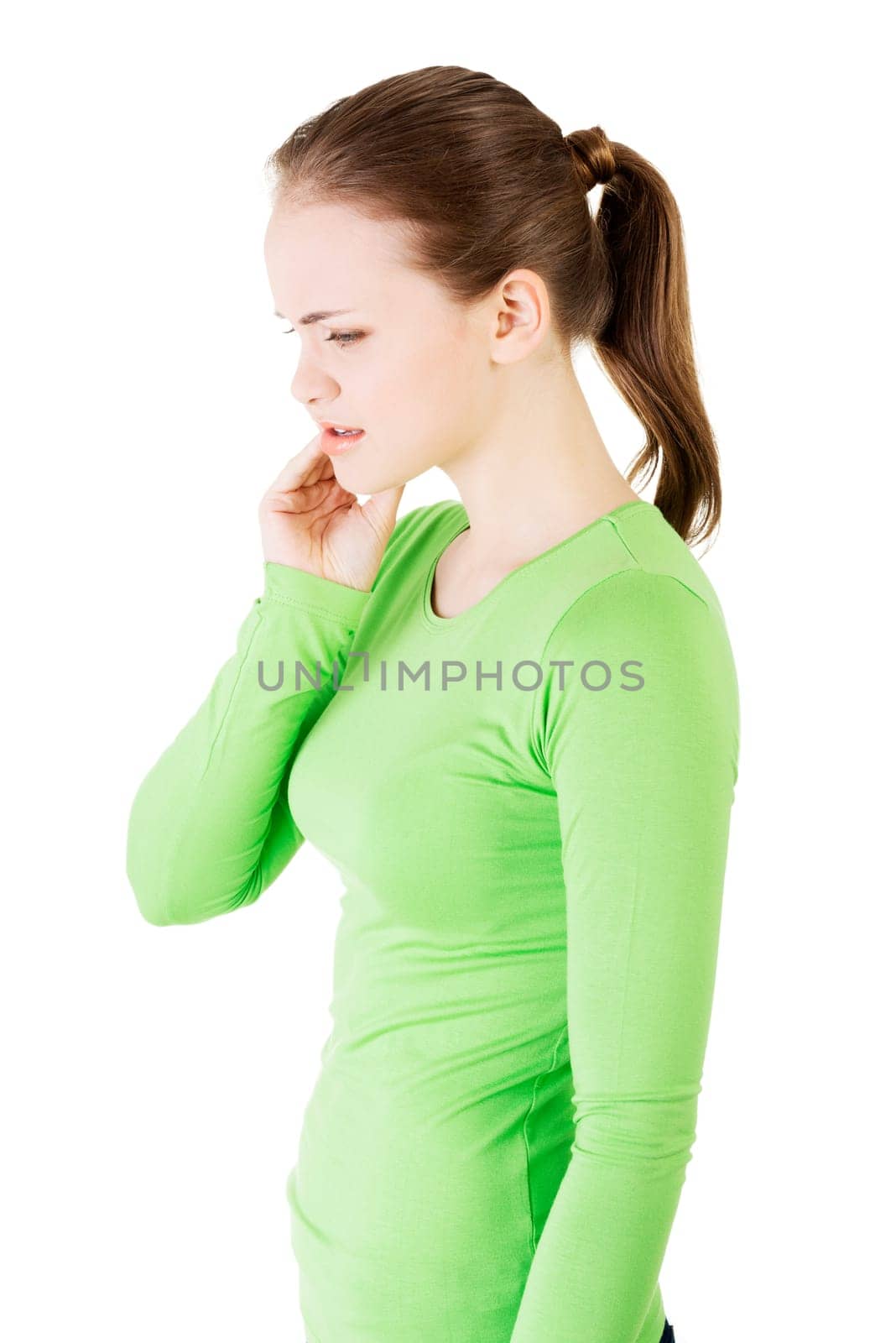 Teen woman pressing her bruised cheek with a painful expression as if she's having a terrible tooth ache.