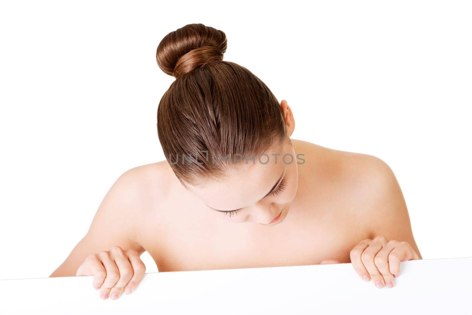 Beautiful woman with perfect skin and beautyful face holding blank board. Isolated on a White Background.