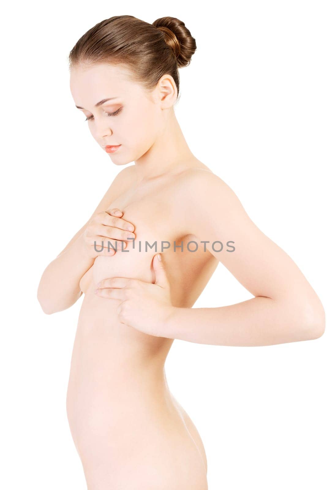 Caucasian adult woman examining her breast for lumps or signs of breast cancer