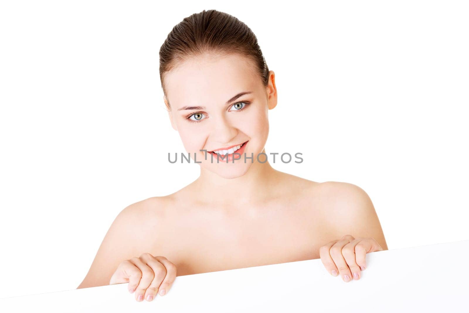 Beautiful woman with perfect skin and beautyful face holding blank board. Isolated on a White Background.
