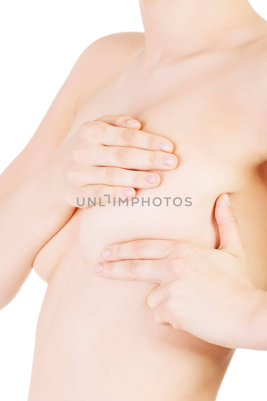 Caucasian adult woman examining her breast for lumps or signs of breast cancer