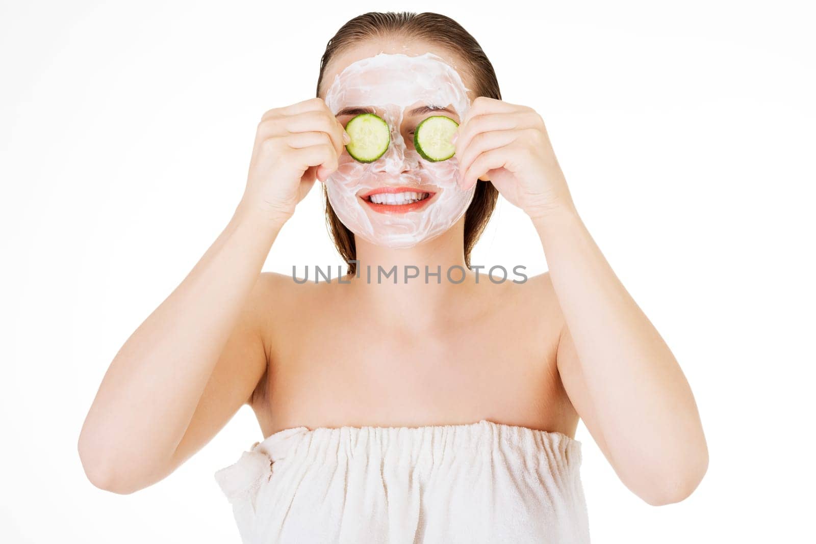 Young woman with cucumber slices  in a spa saloon