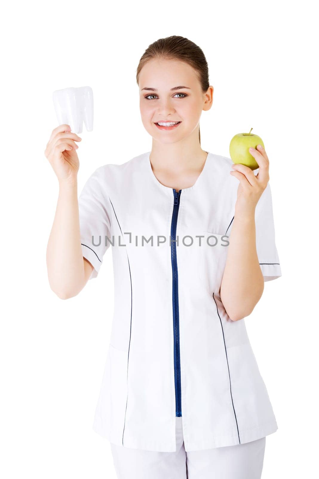 Female dentist with green apple and big tooth. Isolated on white